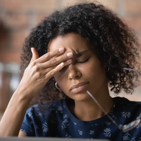 Person holding their forehead in pain.
