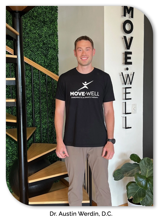 Dr. Austin Werdin smiling next to a Move Well sign.
