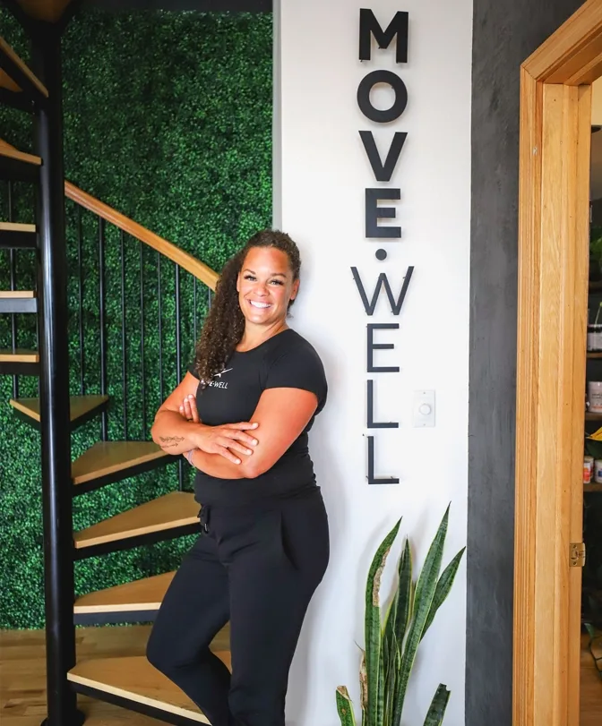 Chiropractor Whitney Rudesill smiling next to a Move Well sign.
